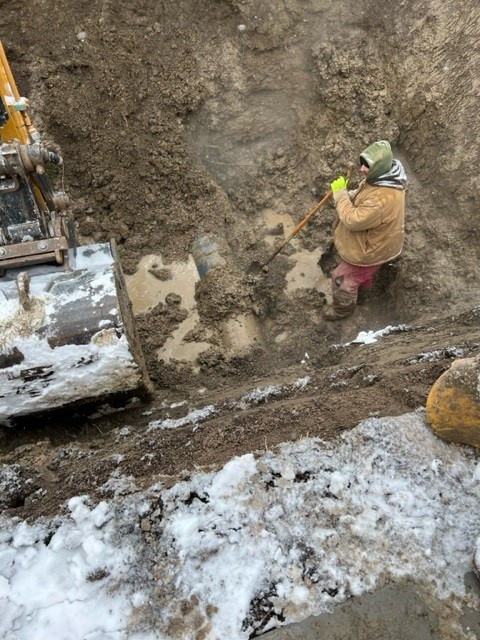 Digging out the broken section of the 16″ pipe, about nine feet down, in challenging conditions